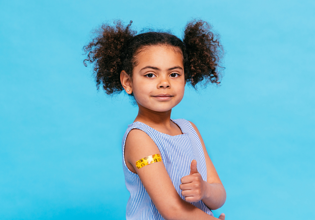 Child giving a thumbs up after getting a vaccination