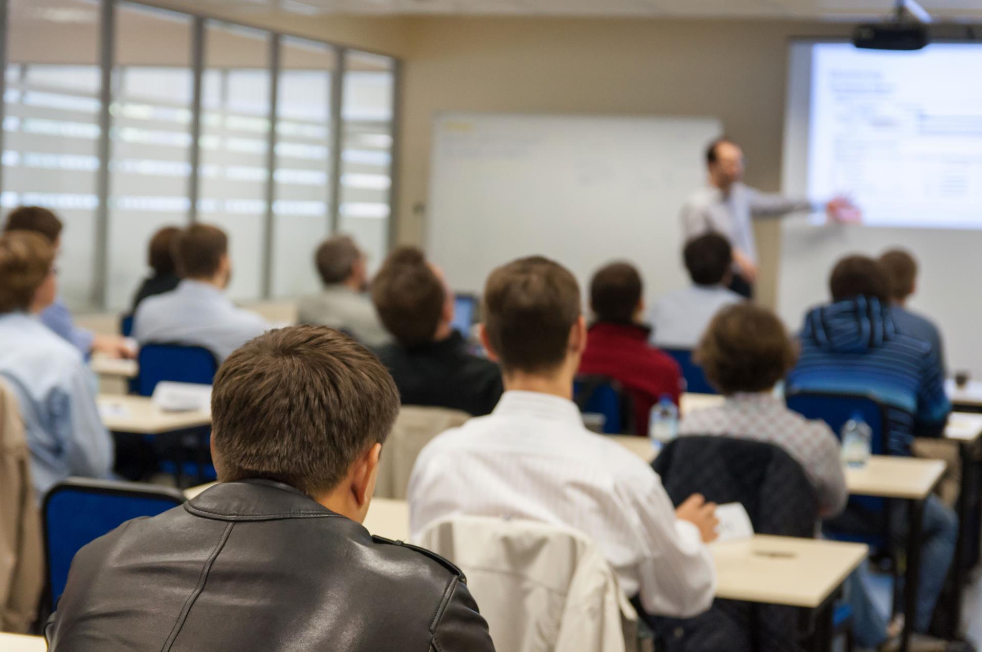 Adults sitting in a classroom listening to a teacher