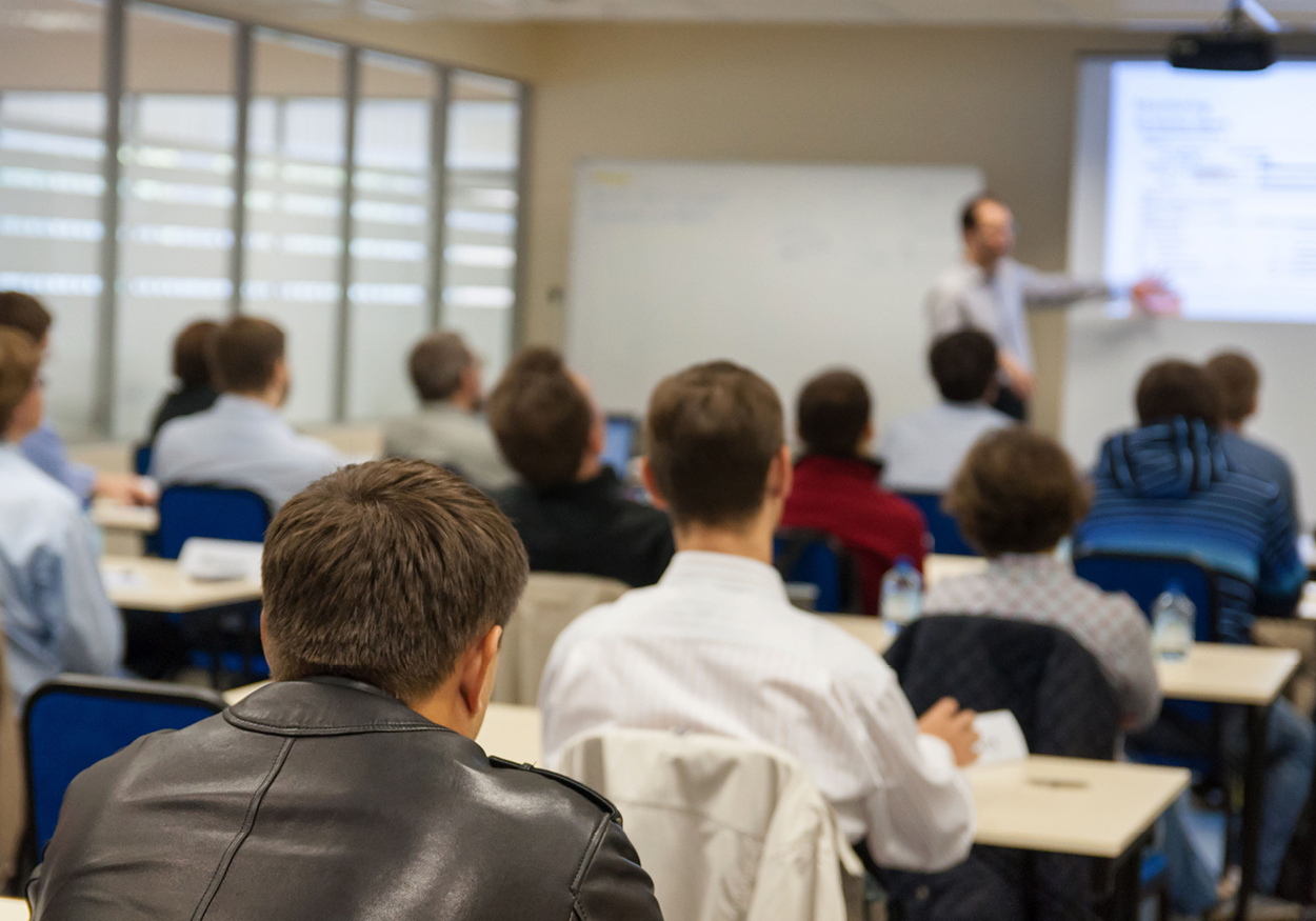 Classroom of adults sitting and listening to a teacher